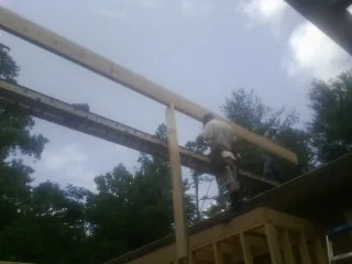Carpenter setting a ridge beam over a new addition frame — Ice Dam Removal by Roofing Brothers in Plympton