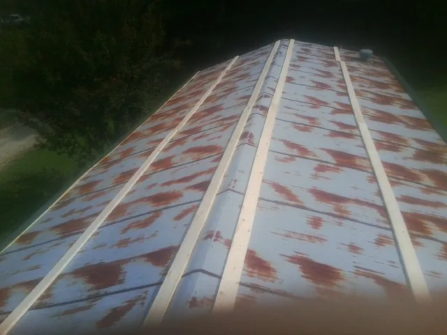 Rusted metal roof panels with new wood purlins before replacement — Storm Damage Roof Repair in Plympton by Roofing Brothers