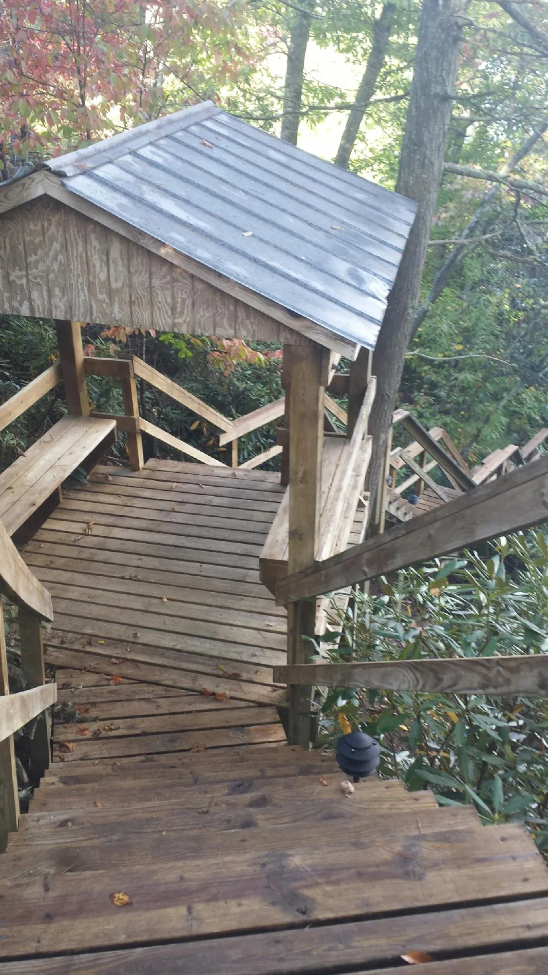 Metal roofed shelter over wooden steps on a wooded walkway — Skylight Repair & Installation work by our crew in Plympton