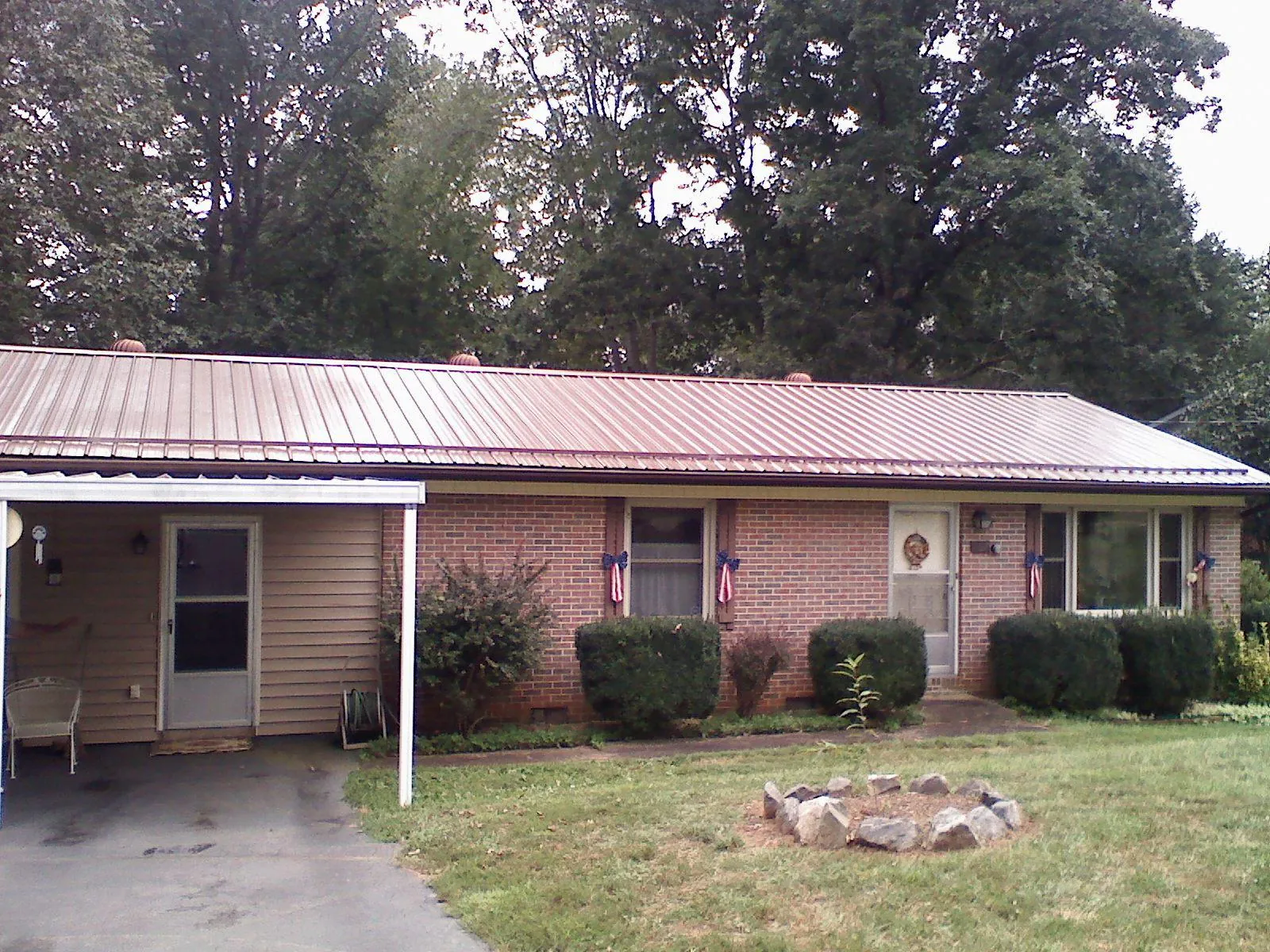 Bronze metal roof and carport on a brick ranch home — Roof Repair work by our crew in Plympton